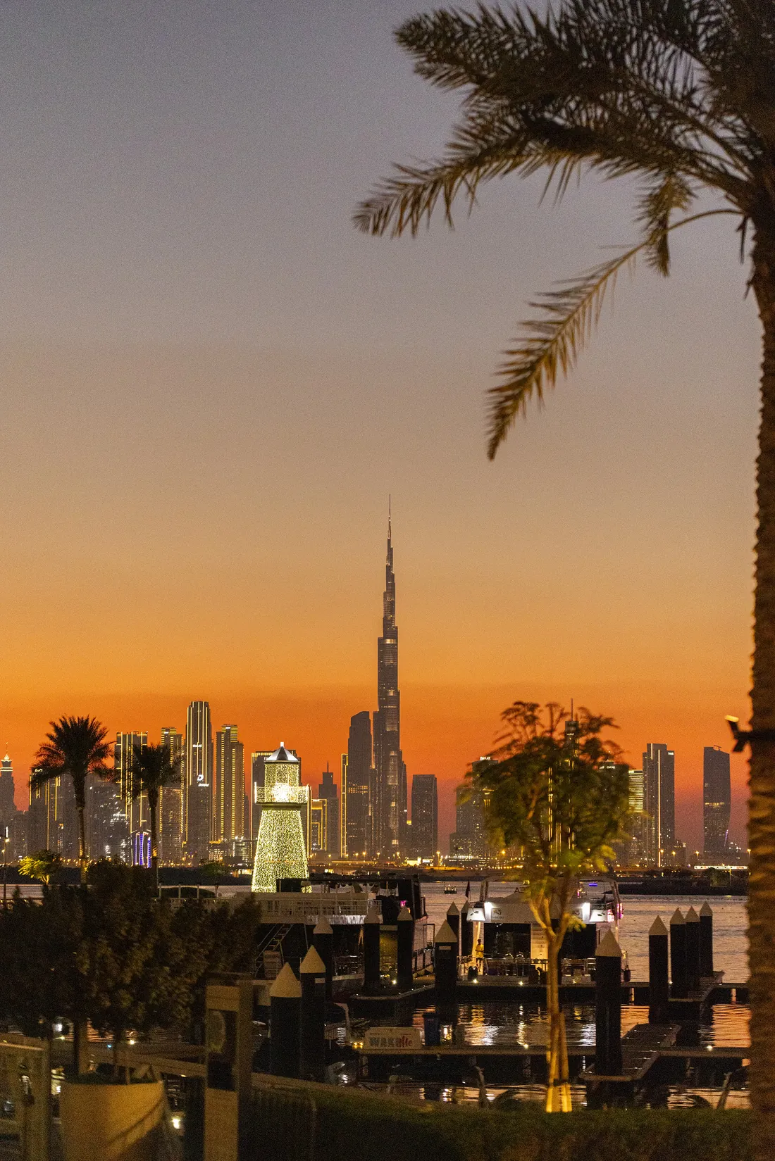 Sunset over the Burj Khalifa and the Downtown Dubai skyline, seen across the water from Dubai Creek Harbour