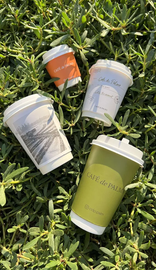Café de Palma cups lying in the greenery