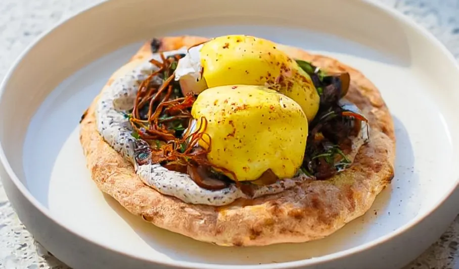 Truffle mushroom Benedict with hollandaise on a round flatbread