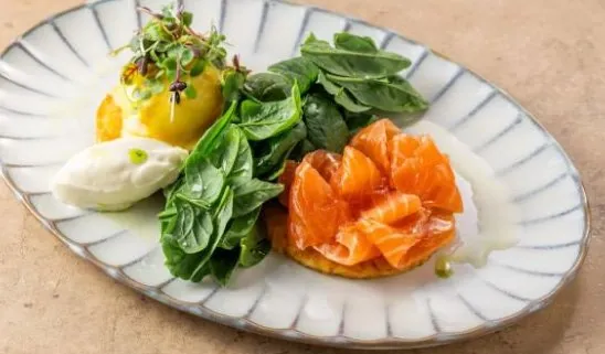 Zucchini fritters with a rose of cured salmon, spinach and sour cream