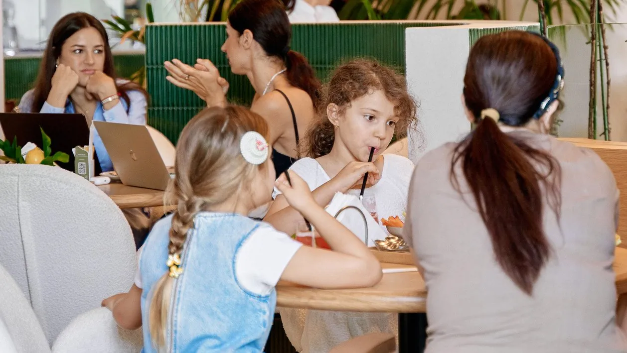 Children and their parents around a table at Café de Palma