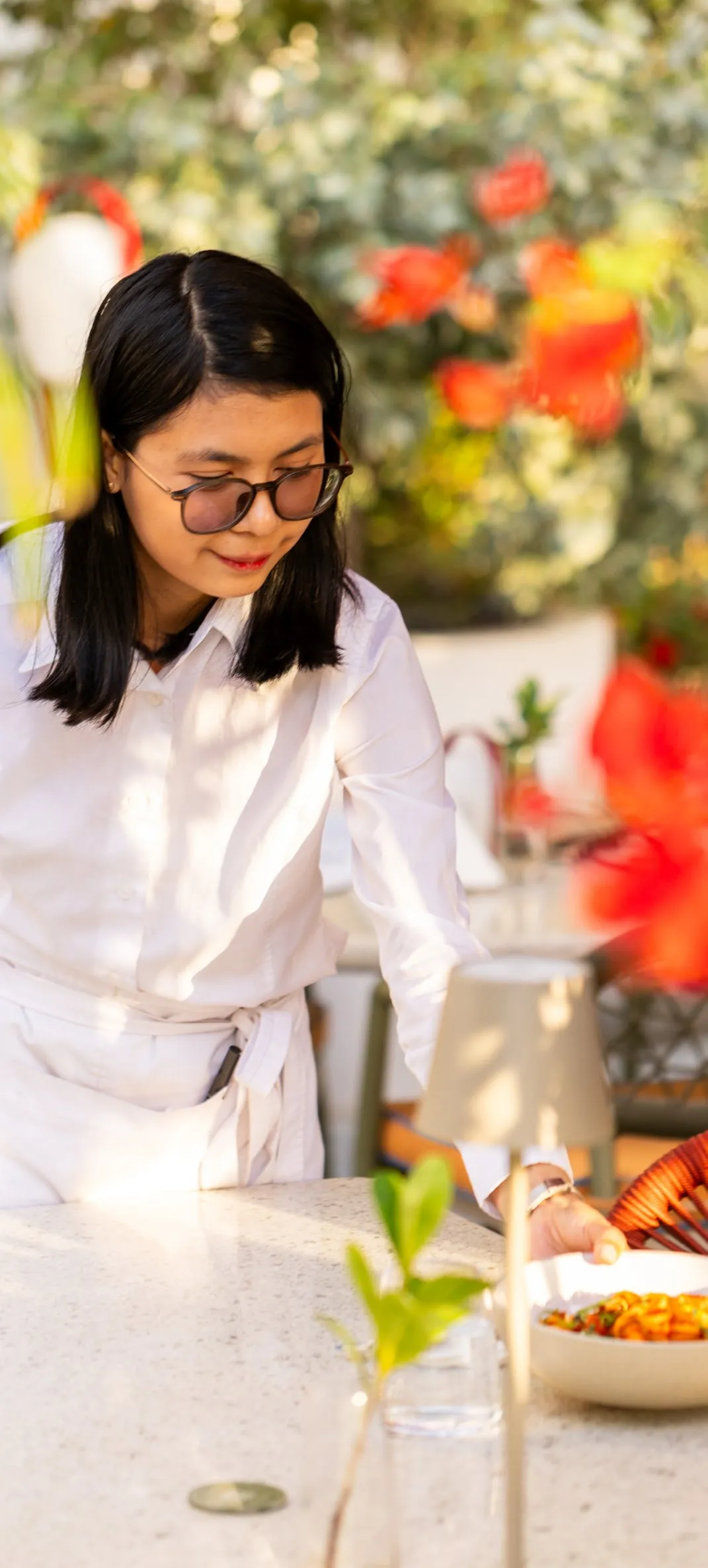 A member of our team setting a table among flowers